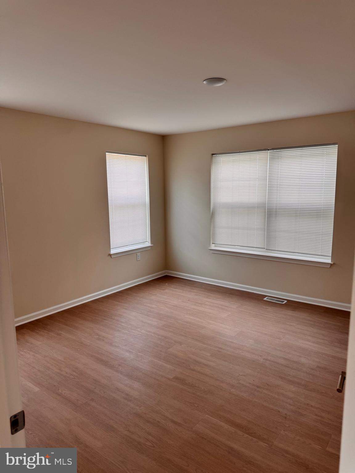 638 Douglas Street Cambridge, MD 21613 - Photo 23 of 30 an empty room with wooden floor and windows