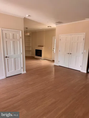 a view of empty room with wooden floor and entryway
