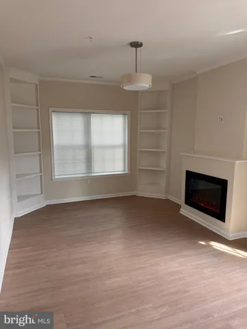 a view of an empty room with a fireplace and a window