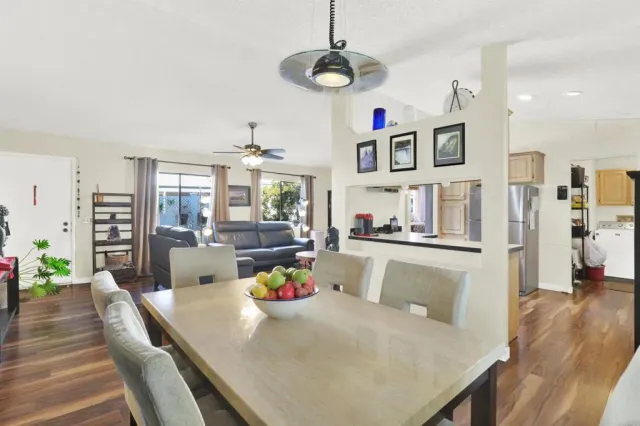 a view of a dining room and livingroom with furniture wooden floor a chandelier