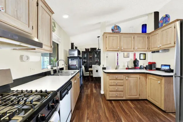 a kitchen with stove a sink and cabinets