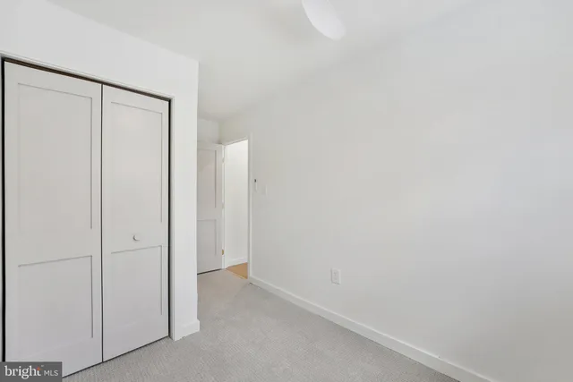 an empty room with a ceiling fan and a window