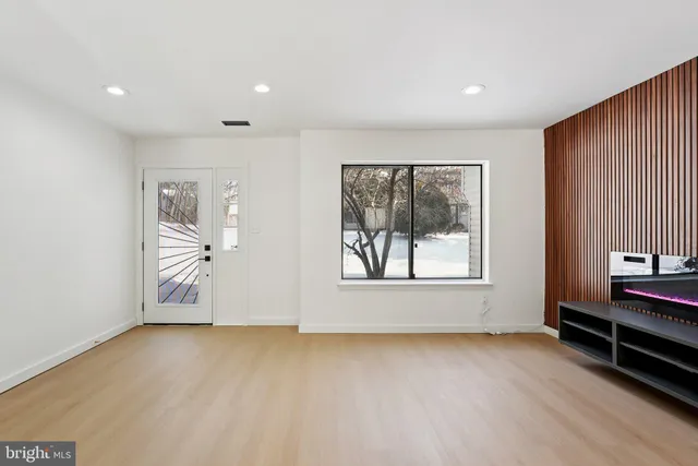 a view of kitchen with stainless steel appliances a sink a stove a refrigerator cabinets and living room view