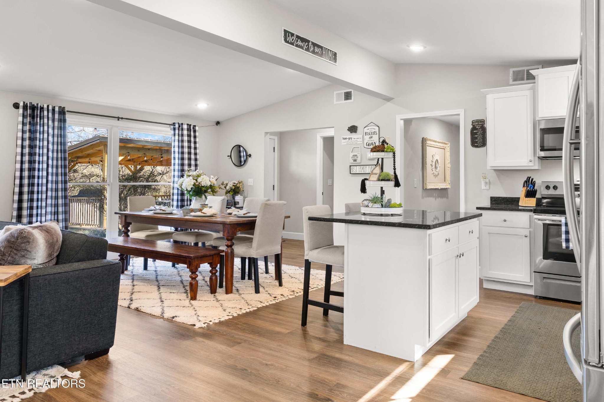 507 Short Street Athens, TN 37303 - Photo 18 of 54 a kitchen with stainless steel appliances granite countertop a stove a refrigerator a dining table and chairs with wooden floor