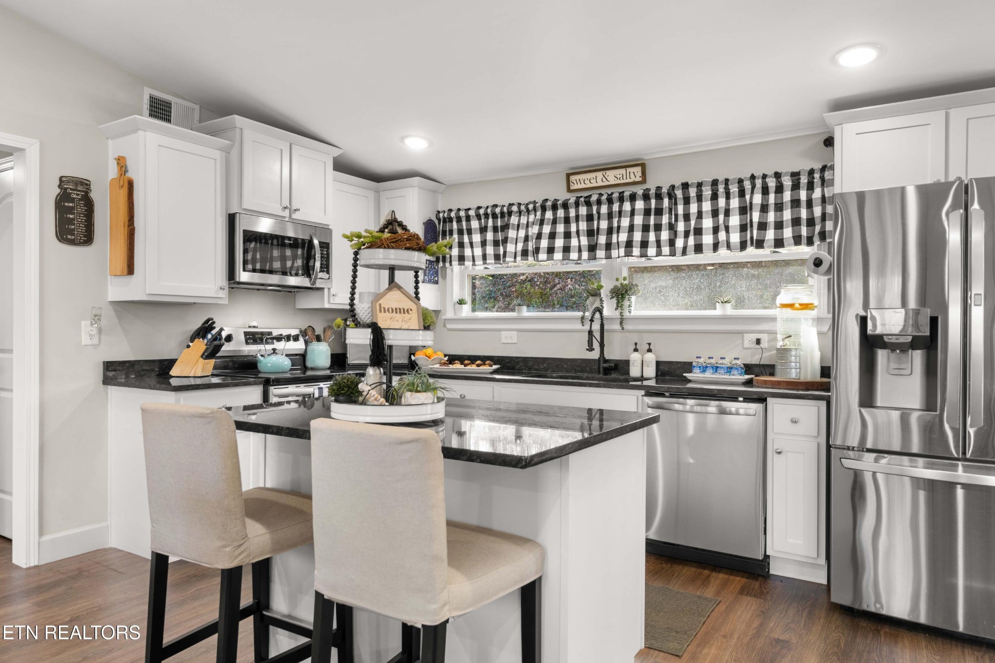 507 Short Street Athens, TN 37303 - Photo 19 of 54 a kitchen with stainless steel appliances granite countertop a stove a sink dishwasher a refrigerator white cabinets and wooden floor