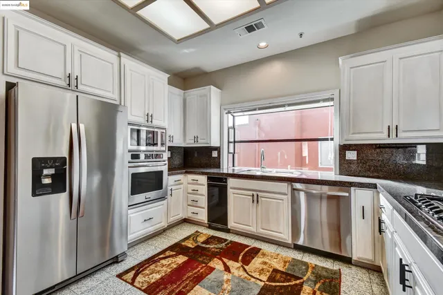 a kitchen with stainless steel appliances a refrigerator sink and stove