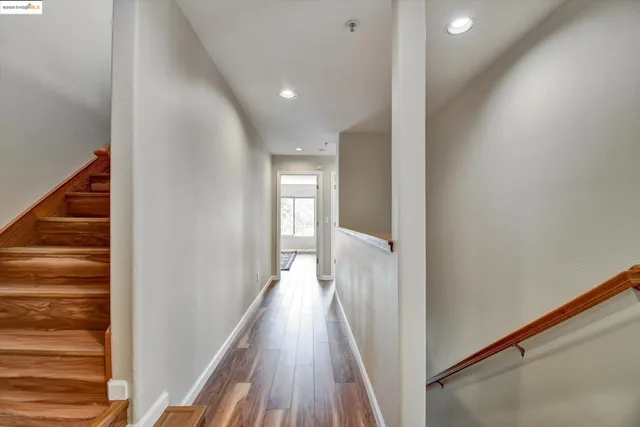 a view of a hallway with wooden floor and staircase