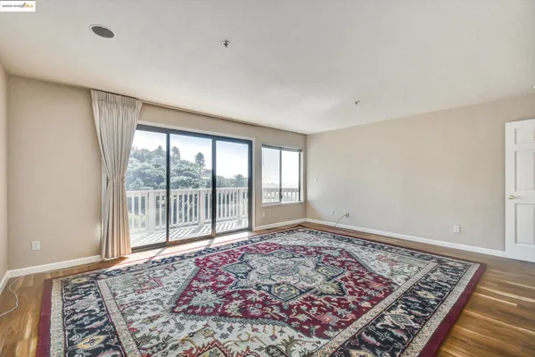 a view of a big room with wooden floor and windows
