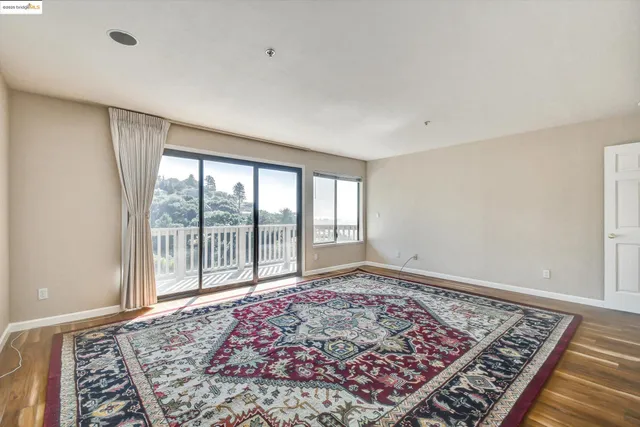 a view of a big room with wooden floor and windows