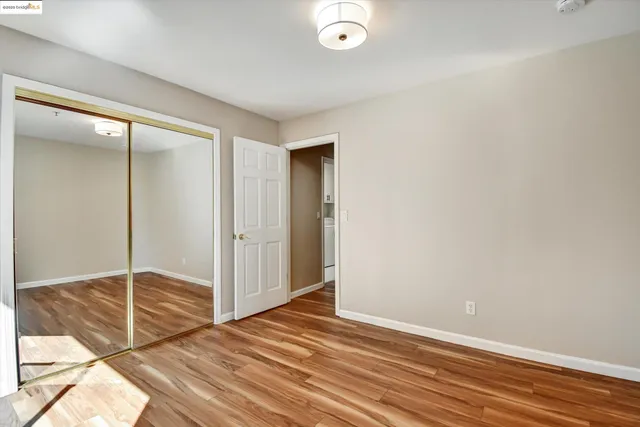 an empty room with wooden floor and sliding door