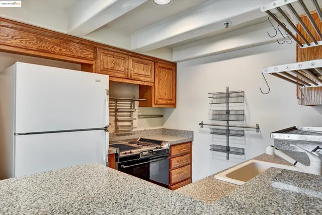 a kitchen with granite countertop a refrigerator and a stove