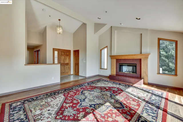 a view of an empty room with window and fire place