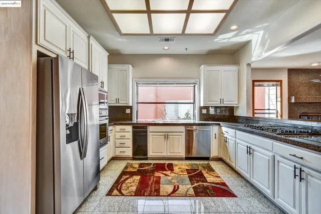 a kitchen with a refrigerator sink and cabinets