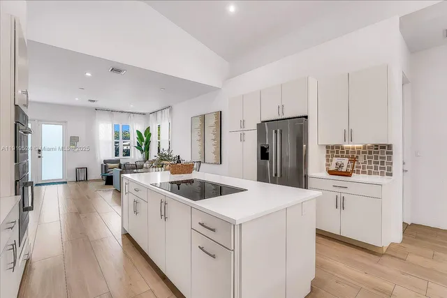 a kitchen with white cabinets and stainless steel appliances