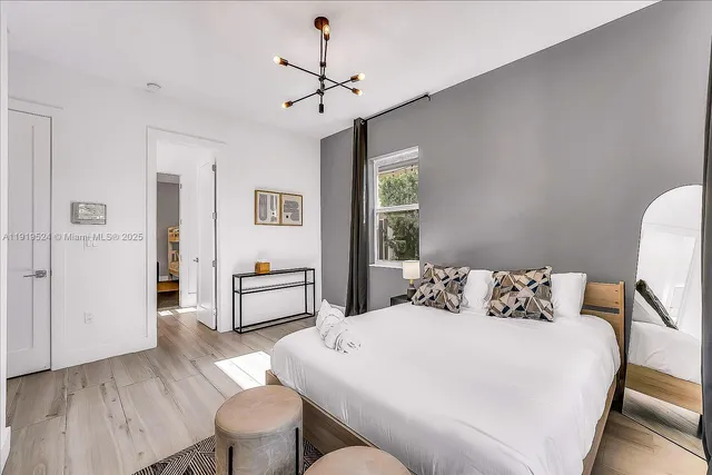 a bedroom with a large bed and a chandelier