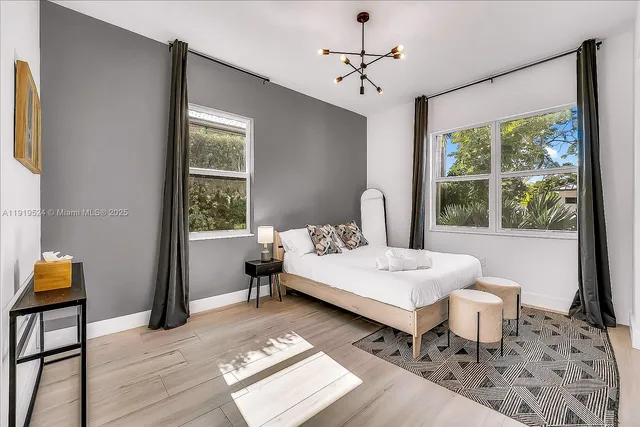 a bedroom with a bed and a table in it with window