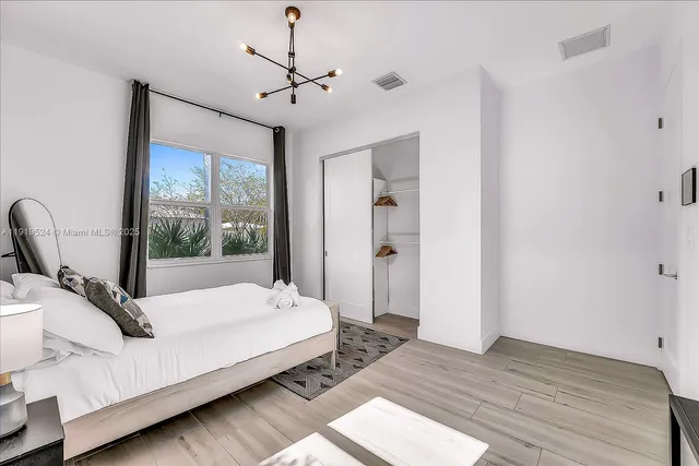 a large bedroom with a bed and wooden floor