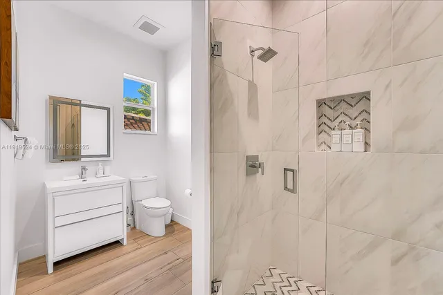 a bathroom with a double vanity sink toilet and shower