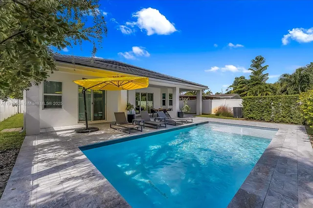 a view of a house with swimming pool and sitting area
