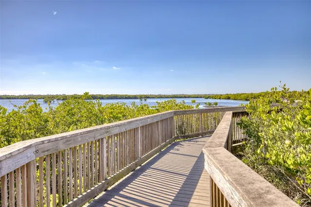 a view of a house with wooden deck and a small yard