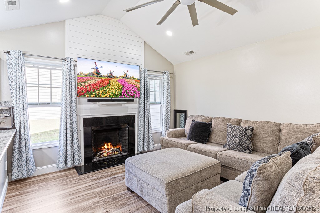 634 Broad Drive Raeford, NC 28376 - Photo 15 of 31 a living room with furniture a fireplace and a ceiling fan