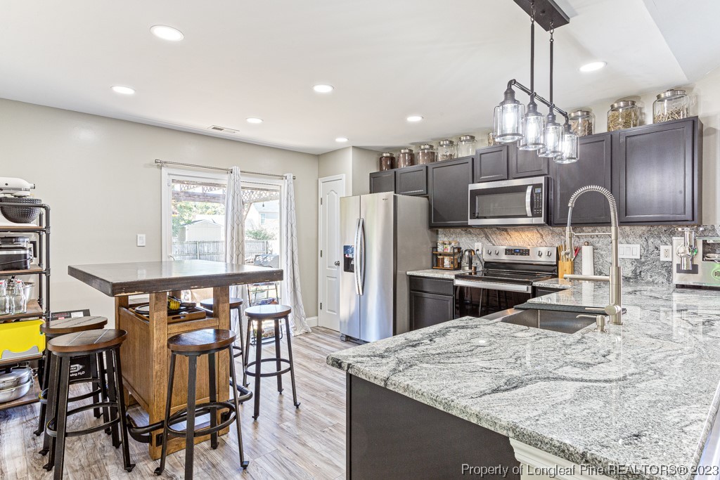 634 Broad Drive Raeford, NC 28376 - Photo 19 of 31 a kitchen with stainless steel appliances refrigerator dining table and chairs