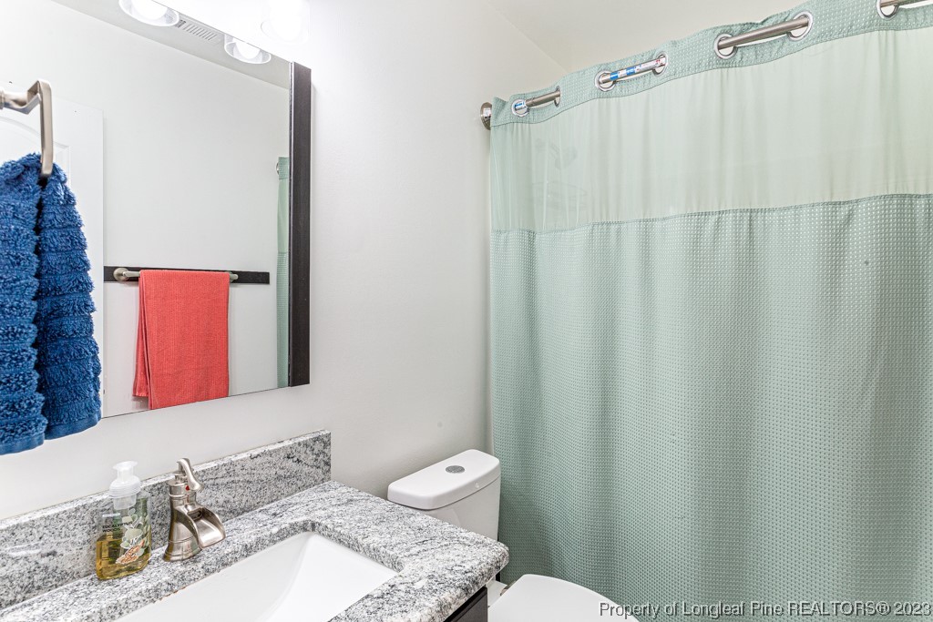 634 Broad Drive Raeford, NC 28376 - Photo 25 of 31 a bathroom with a granite countertop sink and a mirror