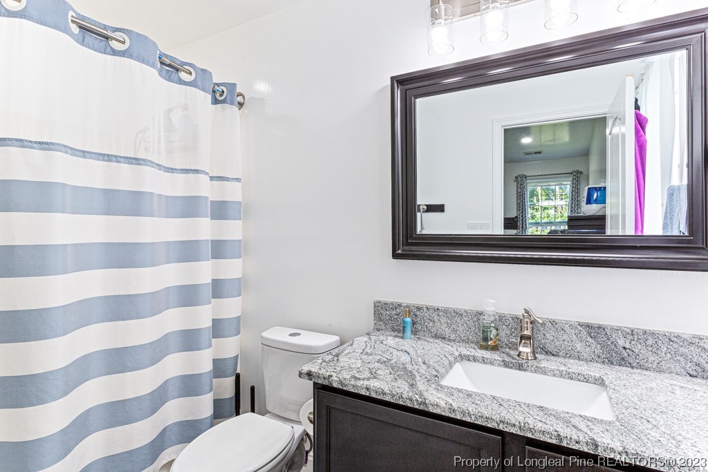 634 Broad Drive Raeford, NC 28376 - Photo 31 of 31 a bathroom with a granite countertop sink and a mirror