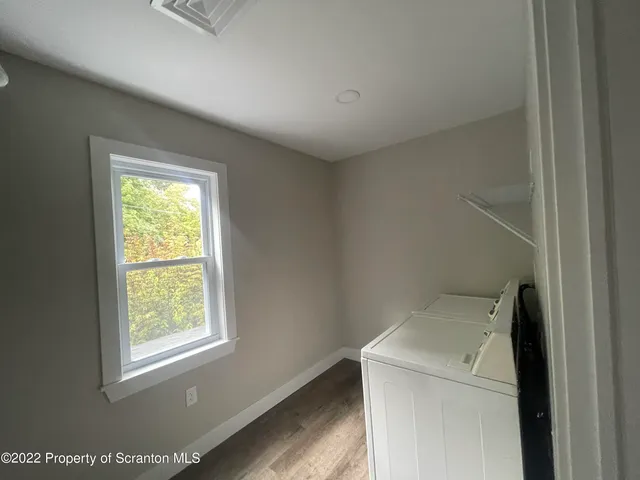 a utility room with dryer and window