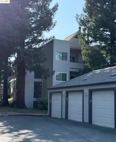a white house with a table and chairs under an umbrella