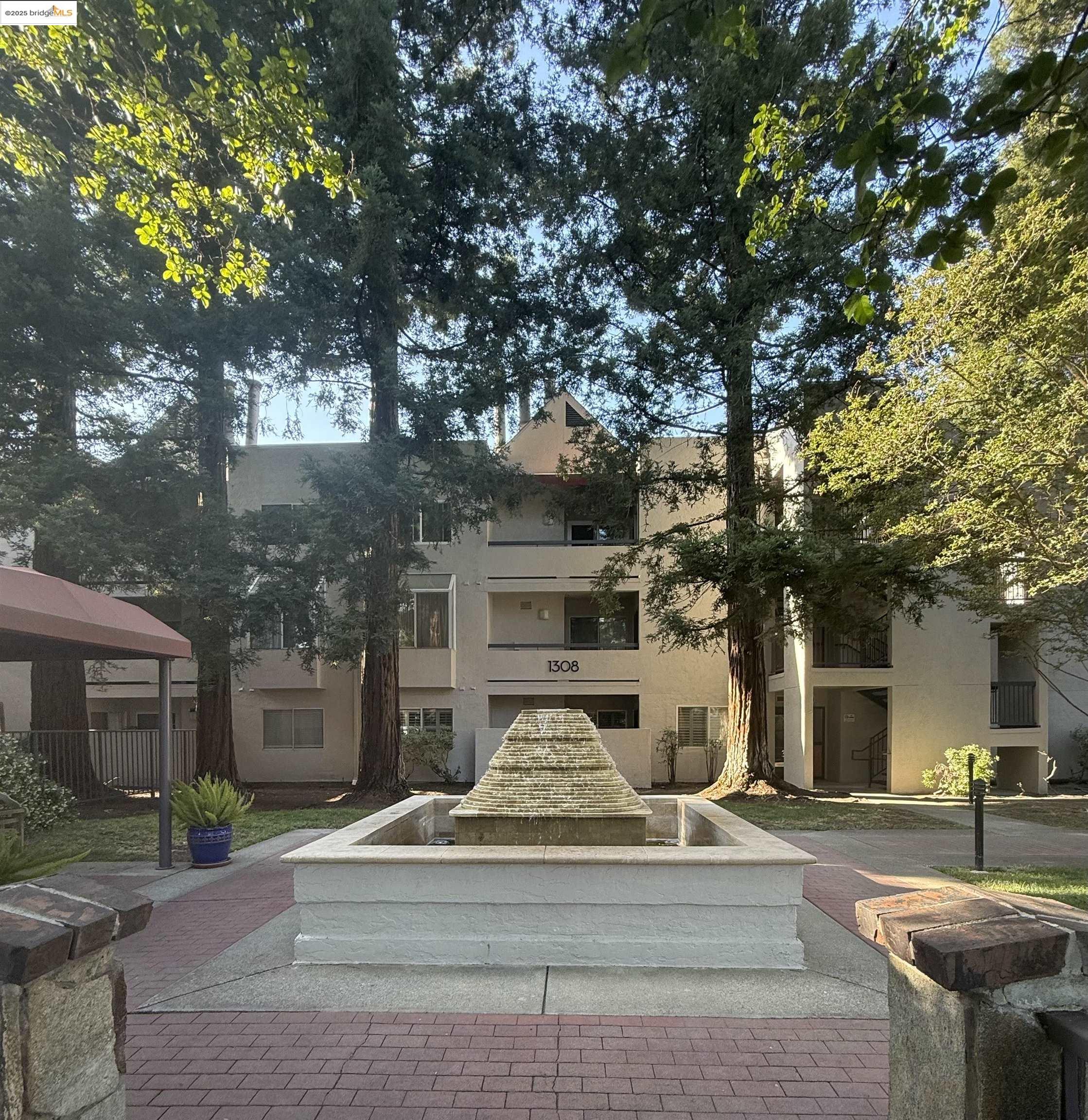 1308 Walden Road, Unit 32 Walnut Creek, CA 94597 - Photo 30 of 43 a view of a white house with a large tree