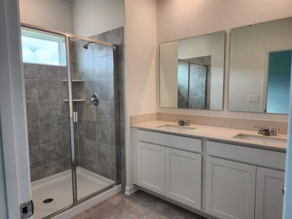 3258 Laurent Loop Davenport, FL 33837 - Photo 18 of 26 a bathroom with a shower sink and mirror