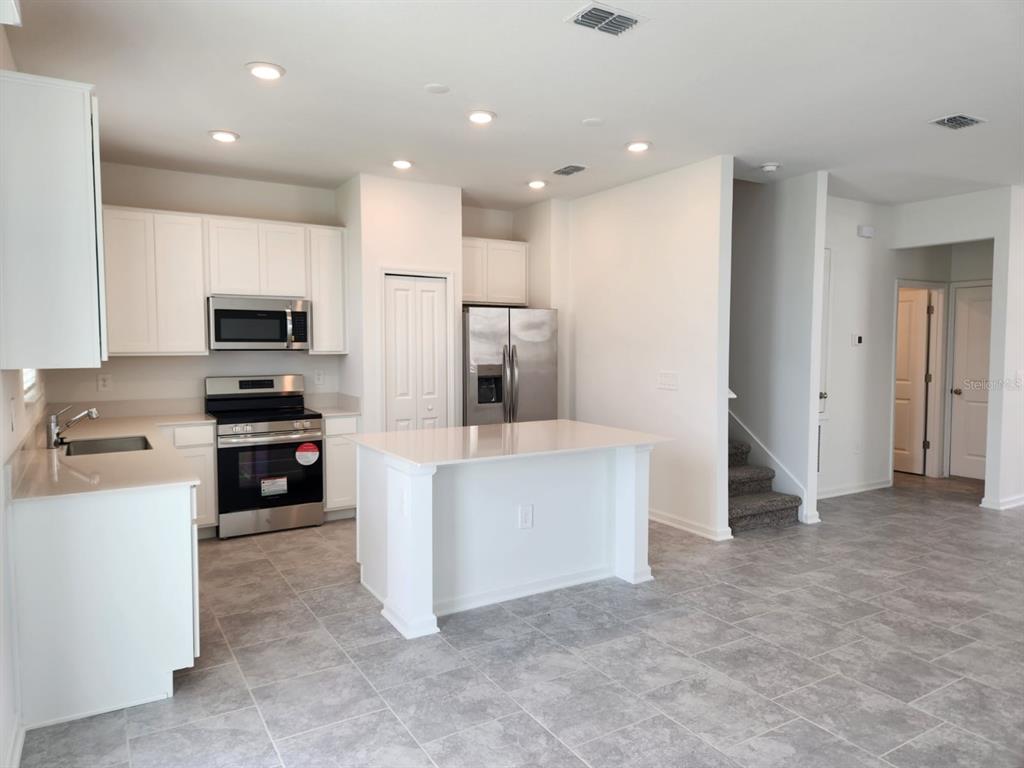 3258 Laurent Loop Davenport, FL 33837 - Photo 5 of 26 a kitchen with kitchen island and stainless steel appliances