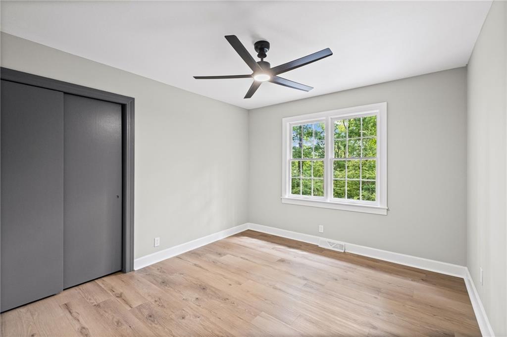 7 East Creekview Drive Southwest Rome, GA 30165 - Photo 20 of 43 an empty room with wooden floor fan and windows