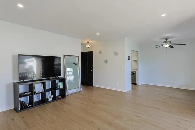 a view of a livingroom with a flat screen tv with wooden floor