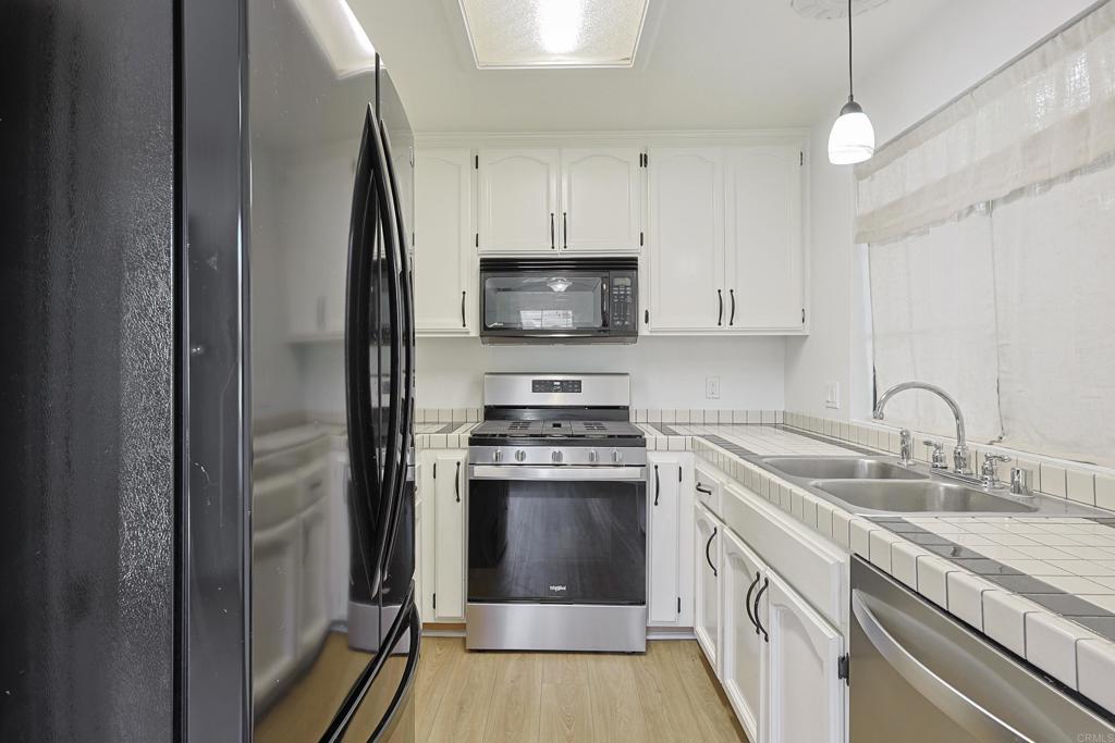 8612 Arminda Circle, Unit 51 Santee, CA 92071 - Photo 25 of 55 a kitchen with stainless steel appliances granite countertop a stove a sink and a refrigerator