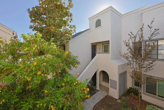 a view of a big house with a big yard and potted plants