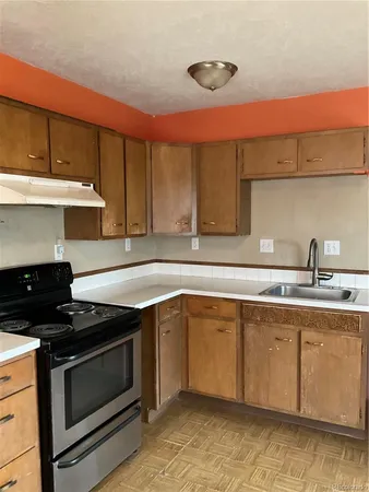 a kitchen with stainless steel appliances granite countertop a sink stove and cabinets