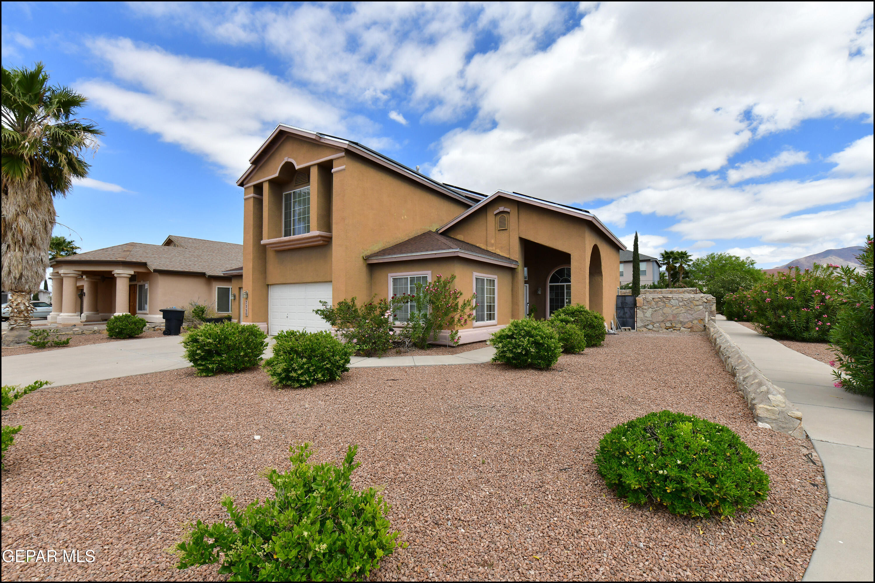 a front view of a house with a yard and potted plants