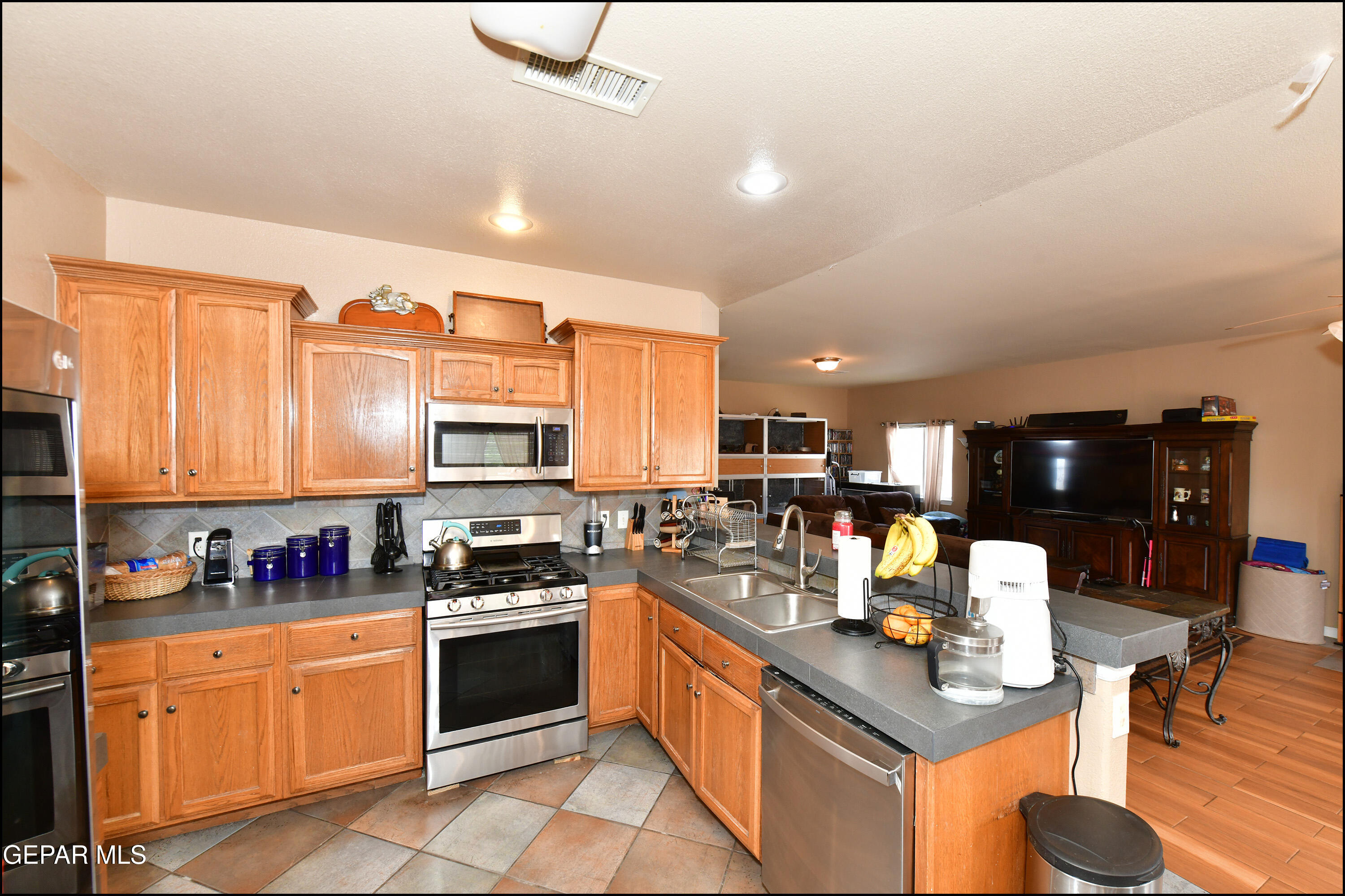 7350 Navidad Way Canutillo, TX 79835 - Photo 16 of 49 a kitchen with stainless steel appliances granite countertop a stove top oven a sink dishwasher and cabinets with wooden floor