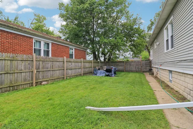 a view of a backyard with wooden fence