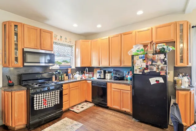 a kitchen with granite countertop a stove a sink dishwasher and a refrigerator