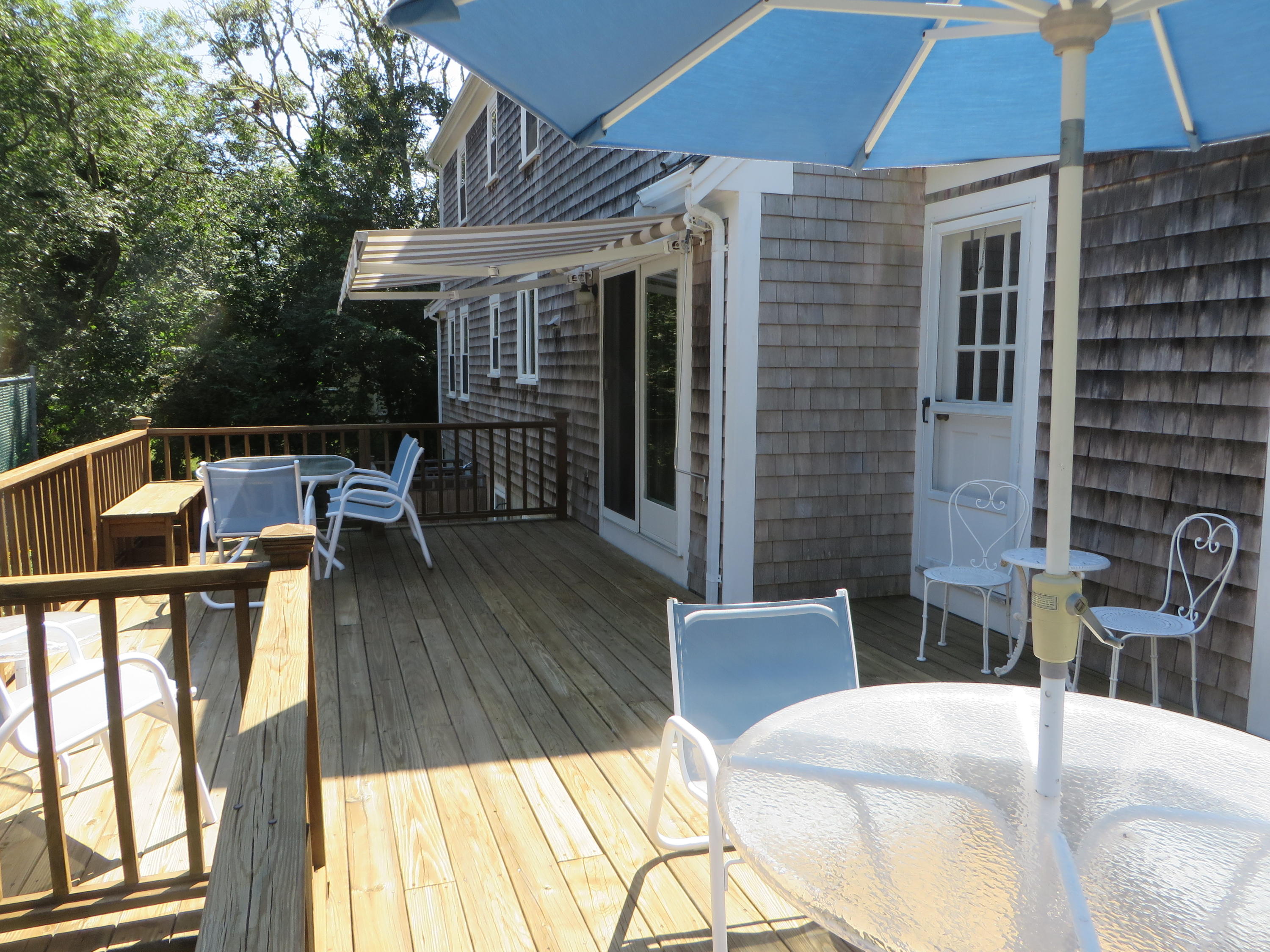 51 Monomoy Road Harwich Port, MA 02646 - Photo 17 of 19 a view of a patio with couches table and chairs under an umbrella
