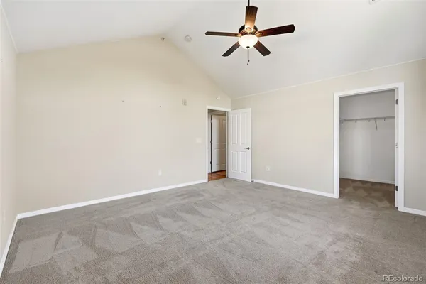 an empty room with a ceiling fan and window