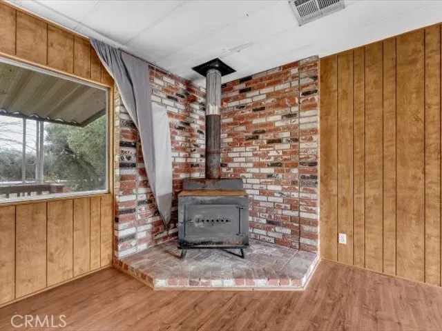 a view of an empty room with wooden floor and closet area