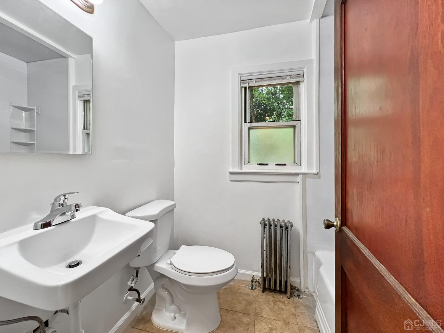 48 Riverview Avenue Edison, NJ 08817 - Photo 12 of 19 a bathroom with a sink a toilet and a mirror