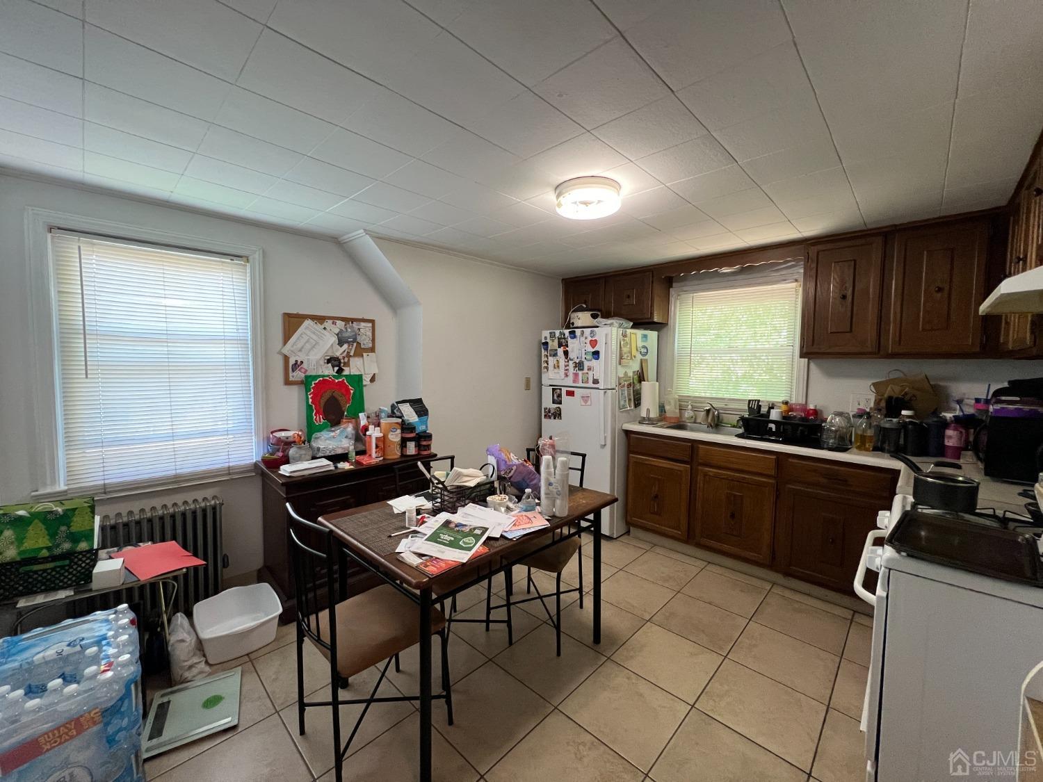 48 Riverview Avenue Edison, NJ 08817 - Photo 15 of 19 a kitchen with a dining table chairs and a refrigerator