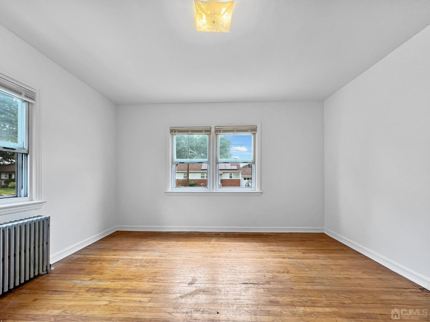48 Riverview Avenue Edison, NJ 08817 - Photo 5 of 19 an empty room with wooden floor and windows