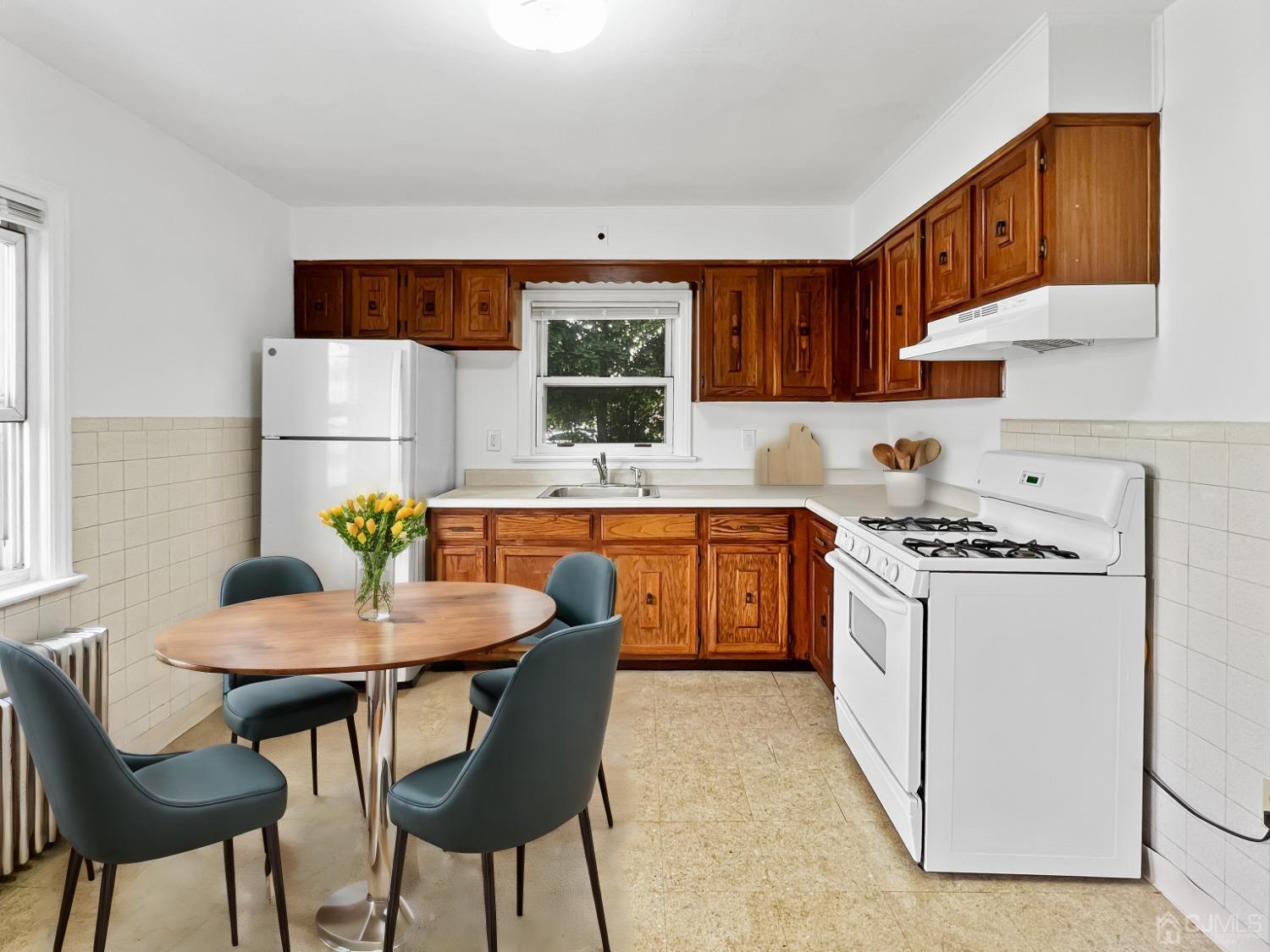 48 Riverview Avenue Edison, NJ 08817 - Photo 10 of 19 a kitchen with a dining table chairs and a refrigerator