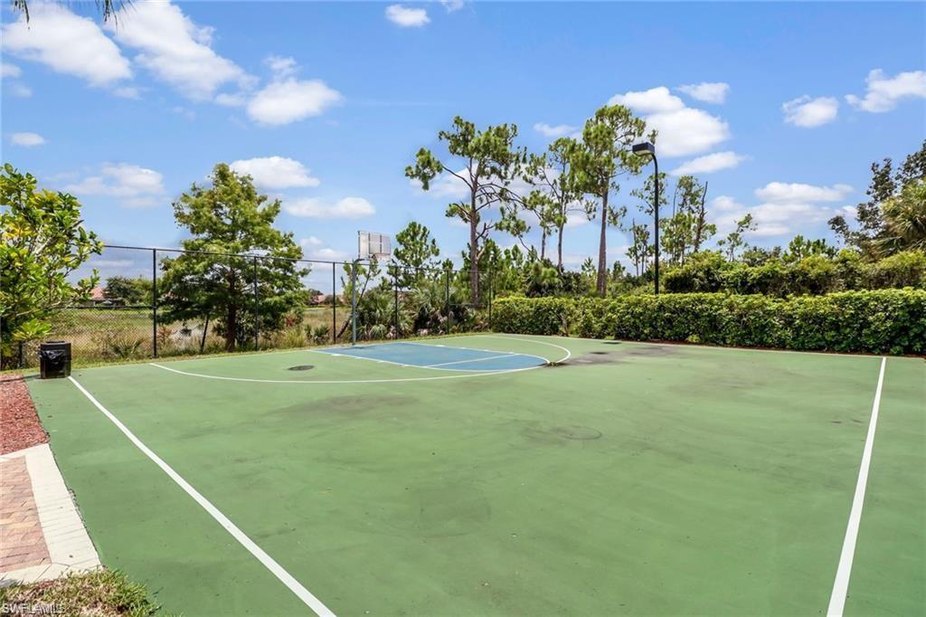15322 Cortona Way Naples, FL 34120 - Photo 18 of 26 a front view of a house with a yard and trees